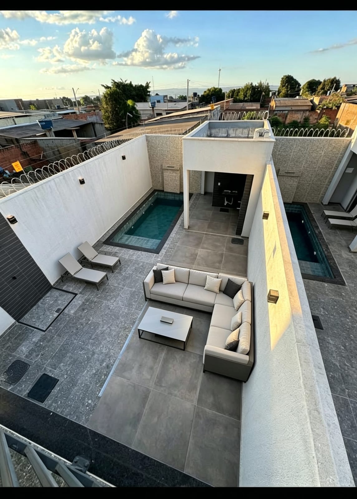 Área externa de imóvel com piscina, espreguiçadeiras e espaço de convivência